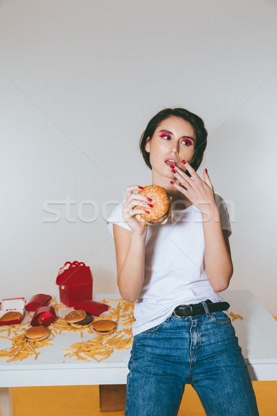 Stok fotoğraf: çekici · genç · kadın · ayakta · yeme · hamburger · beyaz