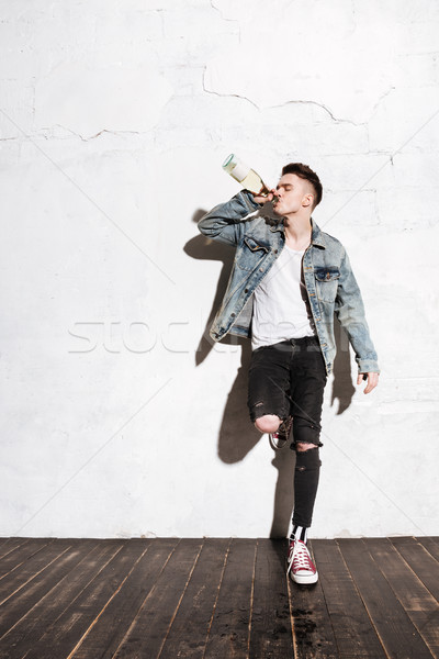 Man standing on floor drinking alcohol posing Stock photo © deandrobot