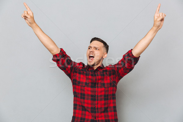 Feliz gritando homem indicação para cima camisas Foto stock © deandrobot