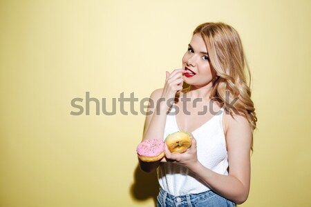 Sexy woman with bright lips makeup holding donuts. Stock photo © deandrobot