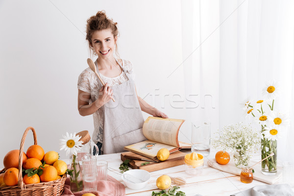 Woman standing indoors near table with a lot of citruses Stock photo © deandrobot