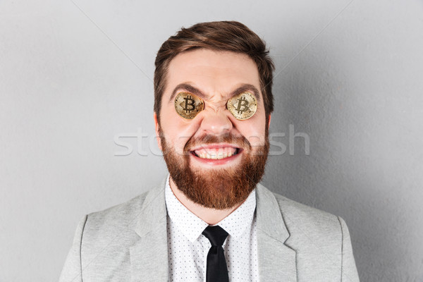 Close up of a cheerful businessman with bitcoins Stock photo © deandrobot