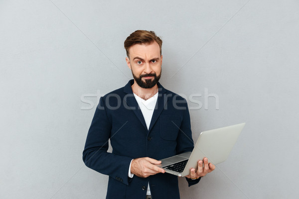 Frown serious man in suit using laptop isolated Stock photo © deandrobot