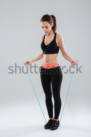 Full length image of Concentrated fitness woman holding dumbbells Stock photo © deandrobot