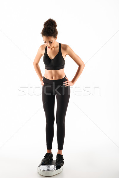 Full length image of Young curly brunette fitness woman Stock photo © deandrobot