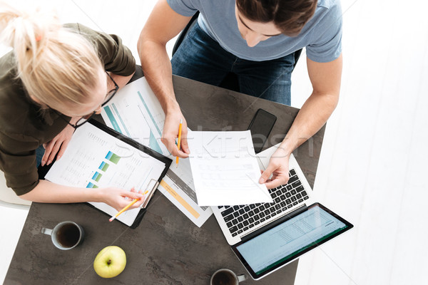 Top view of young couple work with papers and laptop at home Stock photo © deandrobot