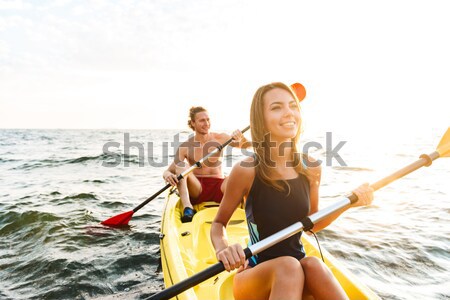 Cheerful young couple kayaking Stock photo © deandrobot