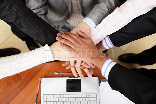 Image of business people hands on top of each other. View from above Stock photo © deandrobot