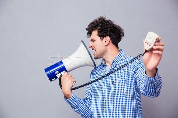 Man directing megaphone at herself Stock photo © deandrobot