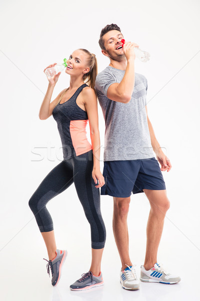 Full length portrait of a couple drinking water Stock photo © deandrobot