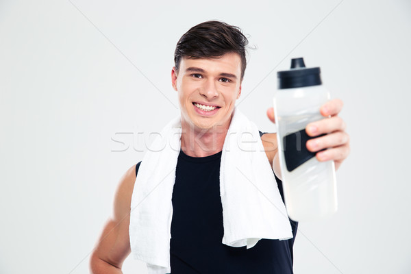 Sports man giving bottle with water at camera Stock photo © deandrobot