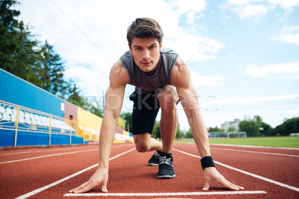Férfi atléta kezdet futás néz kamera Stock fotó © deandrobot