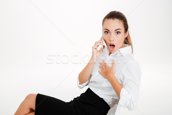 Surprised young businesswoman talking on the mobile phone Stock photo © deandrobot