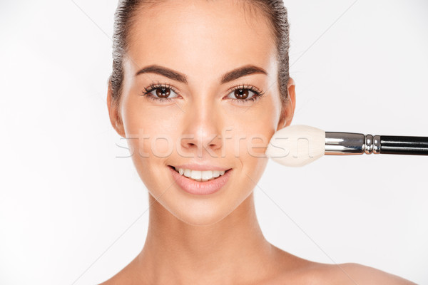 Beautiful young woman apply powder on her face Stock photo © deandrobot