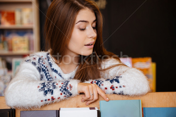 Jonge vrouwelijke student kiezen boeken bibliotheek Stockfoto © deandrobot