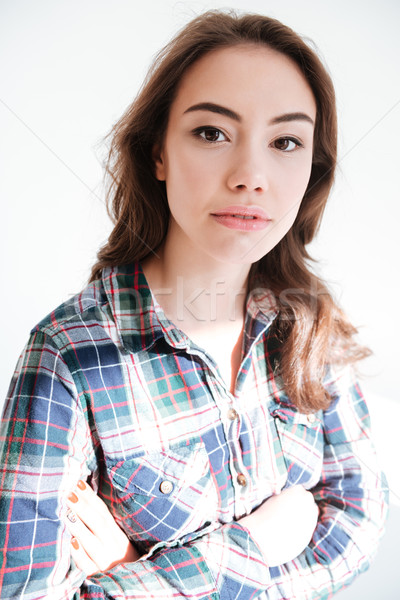 Attractive young woman in plaid shirt standing with hands folded Stock photo © deandrobot