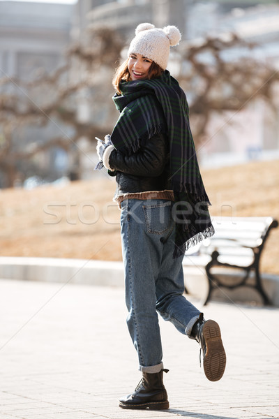 Cheerful woman walking and looking back in the city in autumn Stock photo © deandrobot