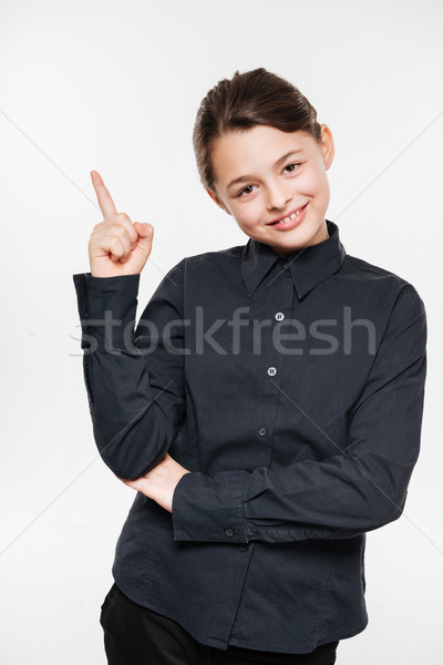 Cheerful young girl posing and pointing Stock photo © deandrobot