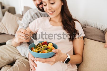 [[stock_photo]]: Enceintes · jeune · femme · manger · salade · de · fruits · canapé