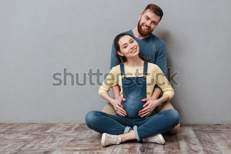 Happy husband and young pregnant woman sitting Stock photo © deandrobot