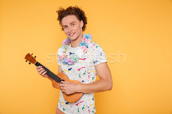 Smiling attractive guy in summer clothes holding ukulele Stock photo © deandrobot