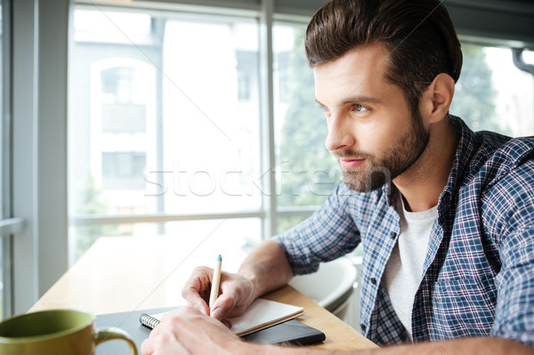 Handsome man in office coworking while writing notes Stock photo © deandrobot