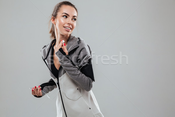 Glimlachend vrouwelijke runner warm kleding luisteren Stockfoto © deandrobot