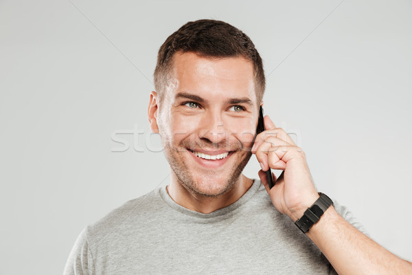 Happy man talking by mobile phone. Stock photo © deandrobot