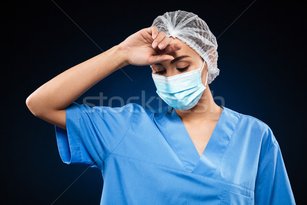 Tired doctor in medical mask and cap wipe sweat isolated Stock photo © deandrobot
