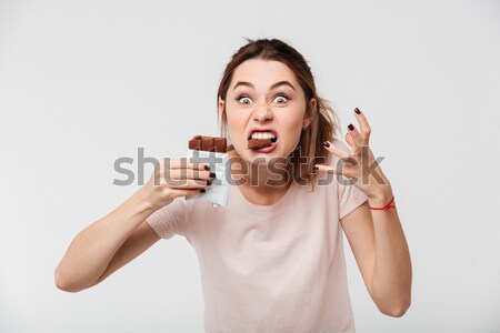 Emotional woman with brown hair in bun expressing surprise while Stock photo © deandrobot