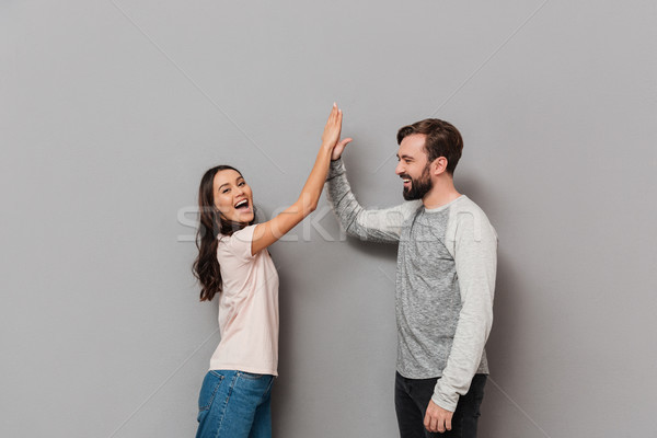 Portrait of a cheery young couple giving high five Stock photo © deandrobot