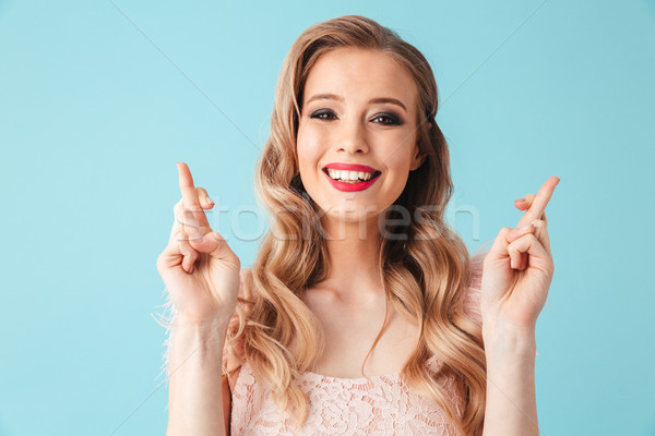 Feliz mujer rubia vestido rezando dedos mirando Foto stock © deandrobot