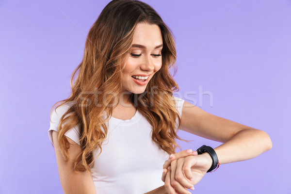 Portrait of a smiling young girl looking at her smartwatch Stock photo © deandrobot