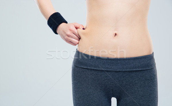 Sporty woman pinch a fat on her abdomen Stock photo © deandrobot