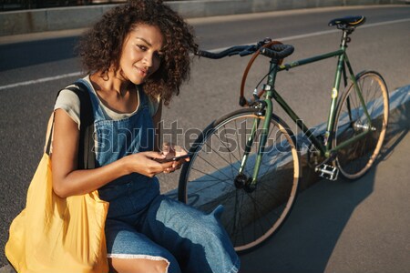 Woman holding bicycle on shoulder Stock photo © deandrobot