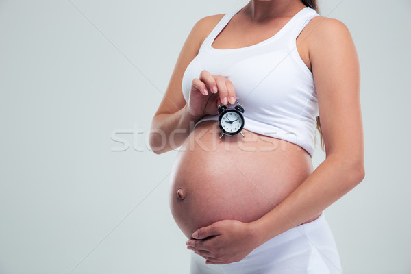 Femeie gravida ceas desteptator portret izolat Imagine de stoc © deandrobot