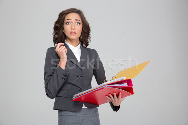 Stunned business woman holding documents in binders Stock photo © deandrobot