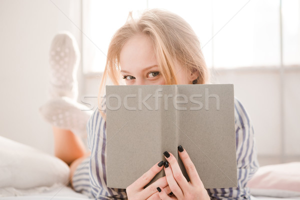 Flörtölő félénk fiatal nő fedett arc könyv Stock fotó © deandrobot