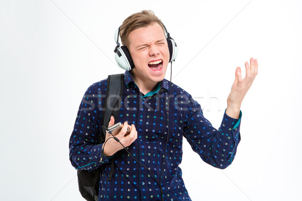 Cheerful male student listening music in headphones  Stock photo © deandrobot