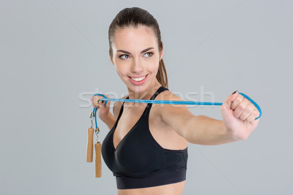 Smiling young sportswoman in black top with jumping rope Stock photo © deandrobot