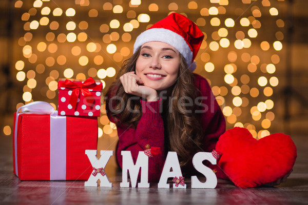 Cheerful beautiful girl lying near letters spelling word Xmas  Stock photo © deandrobot