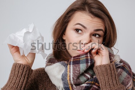 Pensive sad woman with tatoo hiding lipd behind knitted jacket  Stock photo © deandrobot