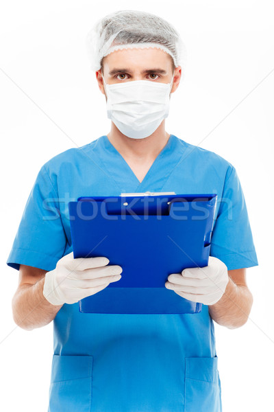 Male surgeon in mask holding clipboard Stock photo © deandrobot