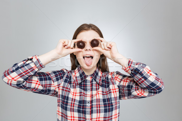 Funny girl covered her eyes with candies and showing tongue Stock photo © deandrobot