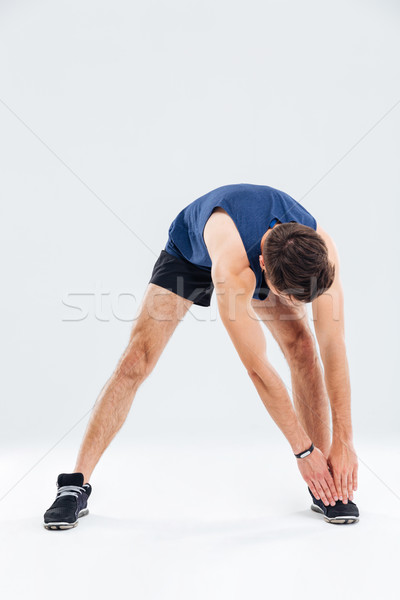 Full length portrait of fitness man stretching and warming up Stock photo © deandrobot