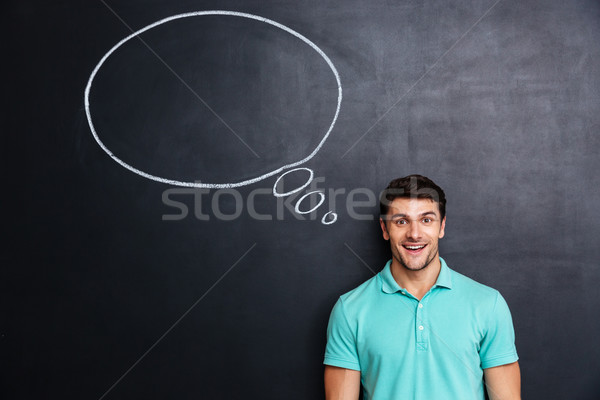 Foto stock: Alegre · homem · em · pé · quadro-negro · balão · de · fala · atraente