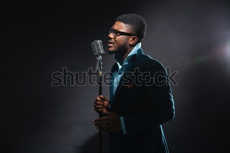 Afro om cântat epocă microfon întuneric Imagine de stoc © deandrobot