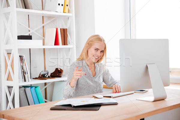 Stock photo: Portrait of a young smiling business woman working with computer
