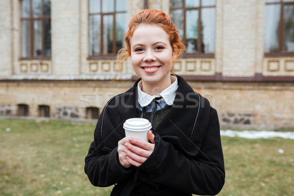 Kobieta student filiżankę kawy patrząc kamery Zdjęcia stock © deandrobot