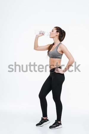 Young healthy sports woman drinking from a water bottle Stock photo © deandrobot